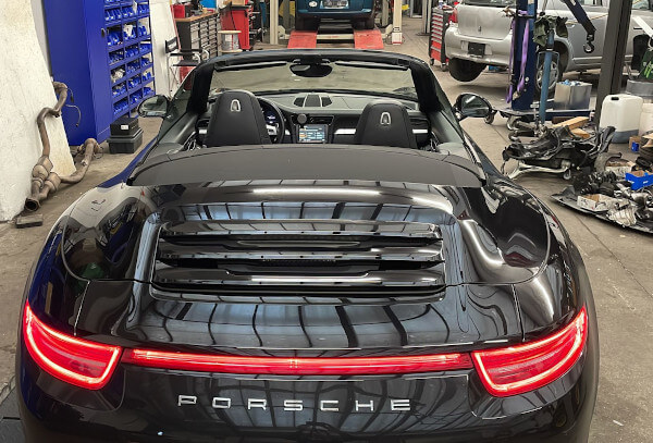 Ein schwarzes Porsche 911 911 Cabriolet steht in der Garage von Fastlane Tuning Schweiz.
